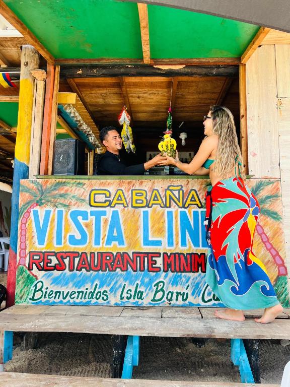 a man and a woman standing in front of a sign at Vista Linda Cabaña in Playa Blanca