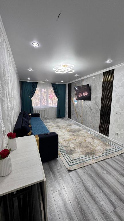 a room with a bed and a tv in it at Квартира посуточно in Balqash