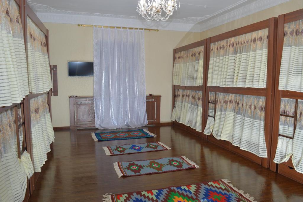 a living room with three mats on the floor at Hostel East Star Khiva in Khiva