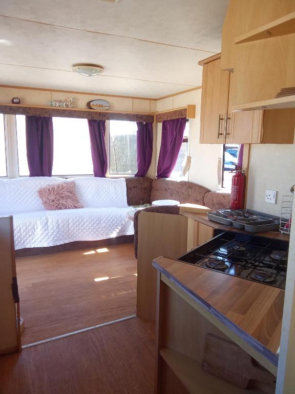 an rv kitchen with two beds and a stove at Sunrise Caravan in Dymchurch
