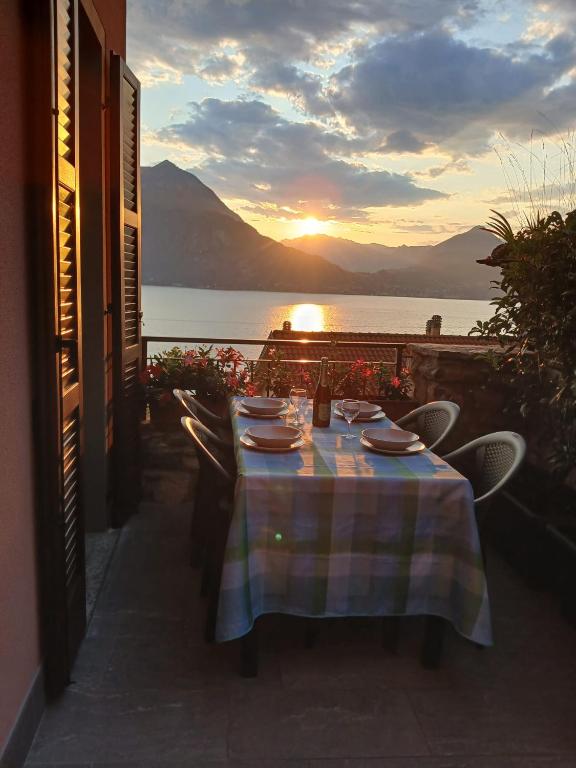 a table on a balcony with a view of the ocean at Rosa House Varenna in Varenna
