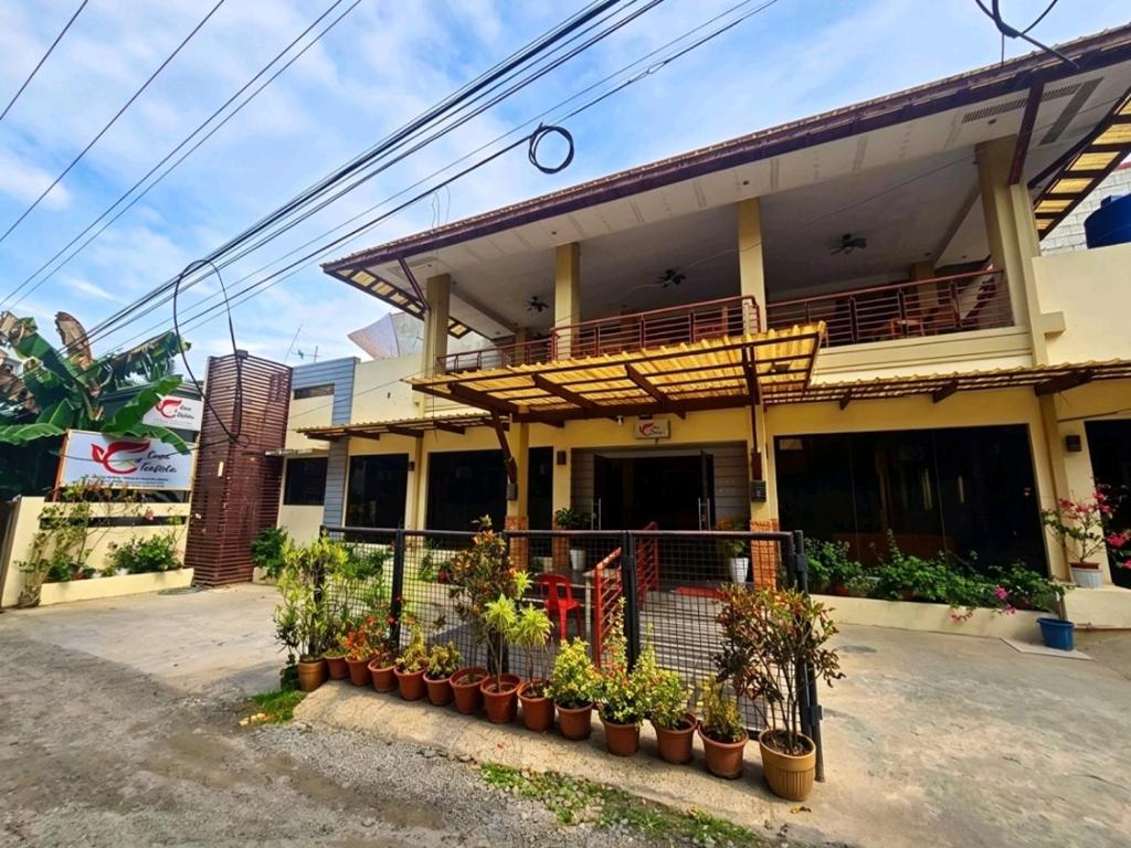 a building with potted plants in front of it at Hotel Casa Teofista in Panglao Island