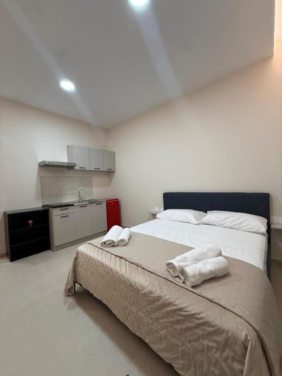 a bedroom with a large bed with towels on it at La Vista Suite and Rooms in Ladispoli