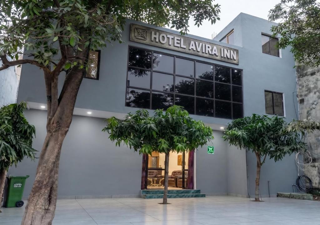 a hotel akhtar inn with trees in front of it at Hotel Avira Inn-Opp Lucknow HighCourt in Lucknow