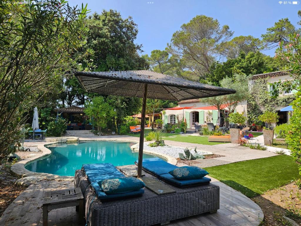 an umbrella sitting next to a swimming pool at Villa piscine jacuzzi Mas la Bregeonière in Roquefort-les-Pins