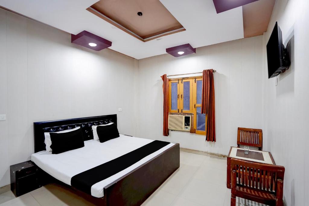 a bedroom with a bed and a window and a television at Hotel O Jhandi Palace in Lakhīmpur