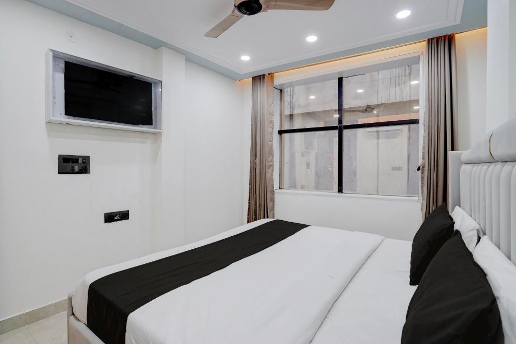 a bedroom with a bed and a large window at Hotel O Bay Inn in New Delhi