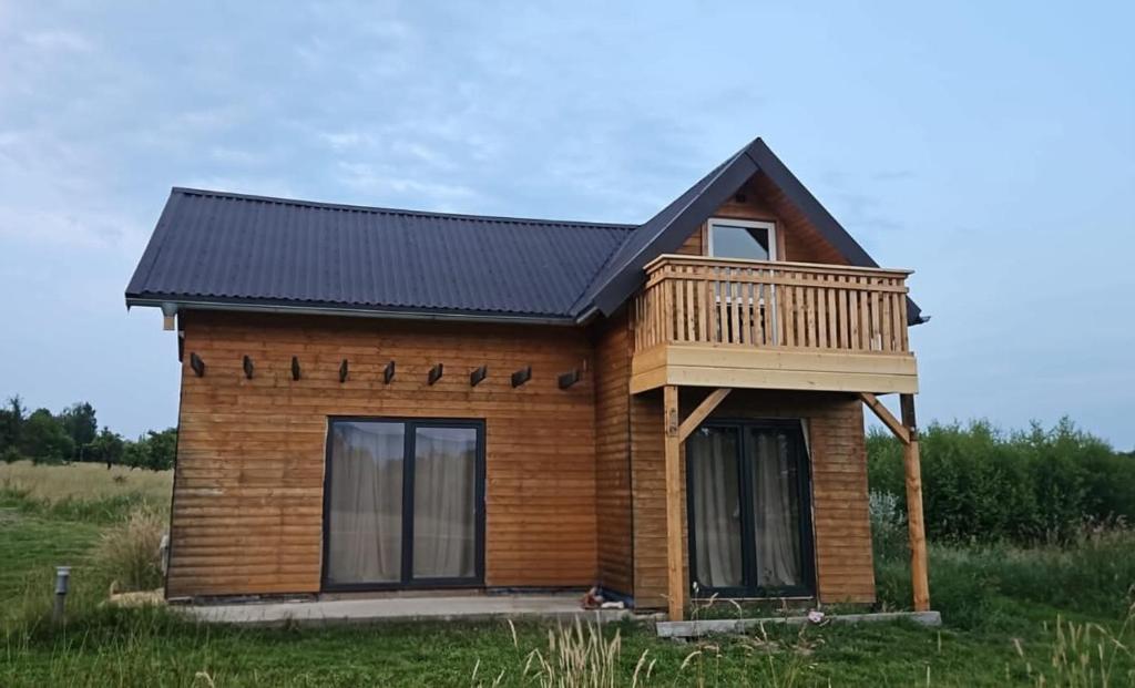 a small house with a deck on a field at Przystań Vianneya in Giebułtów