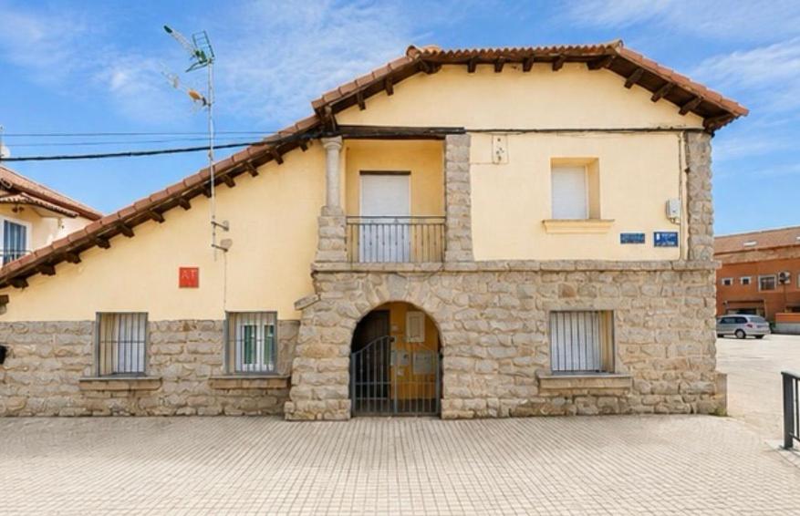 a large stone house with a balcony on top of it at Apartamentos Las Fuentes in Labajos