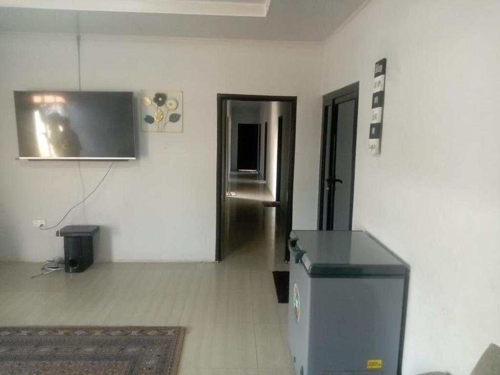 an empty room with a refrigerator and a hallway at Chimwemwe apartments in Chingola