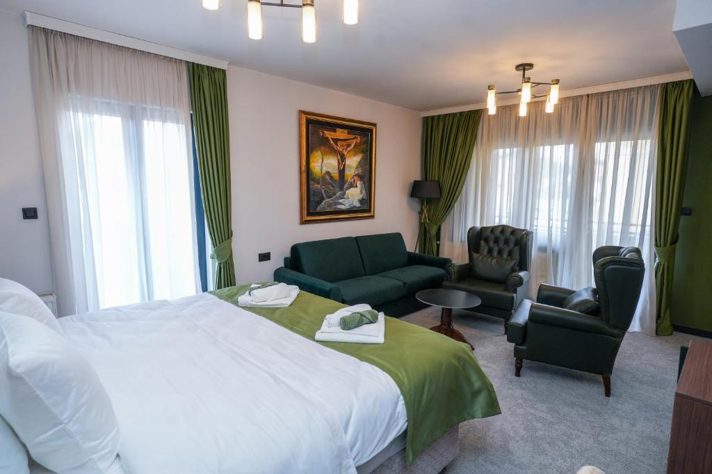 a hotel room with a large bed and a living room at Aurelius Hotel & Restaurant in Pljevlja