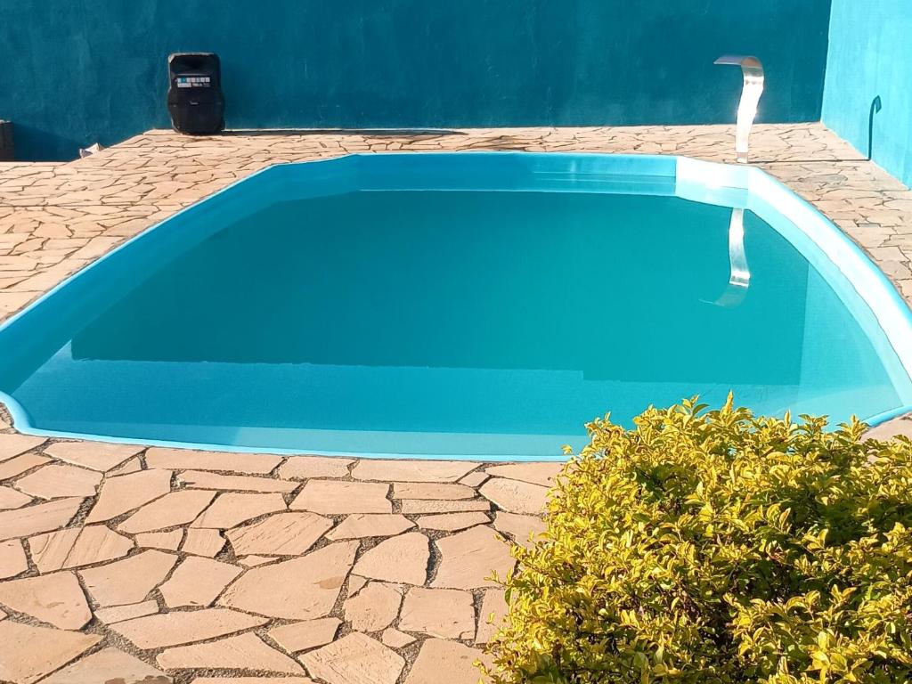 a blue swimming pool sitting on a stone patio at Cantinho,RMA in Bom Jesus dos Perdões