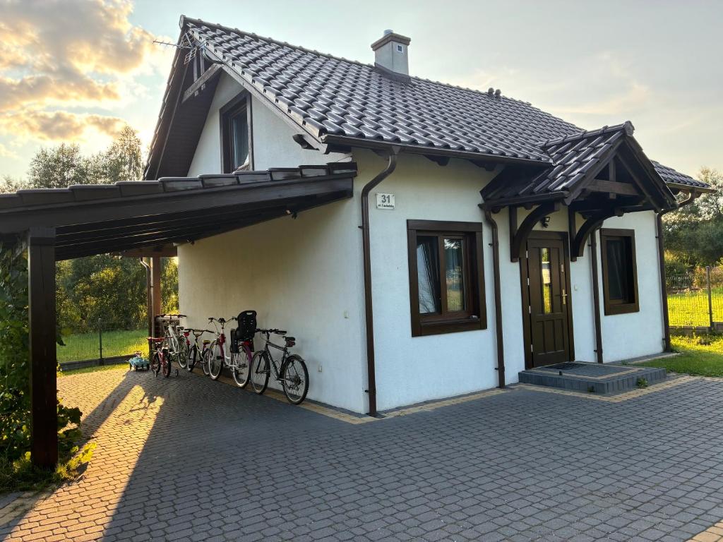 a small white house with bikes parked in it at Domek nad jeziorem w Świekatowie in Świekatowo