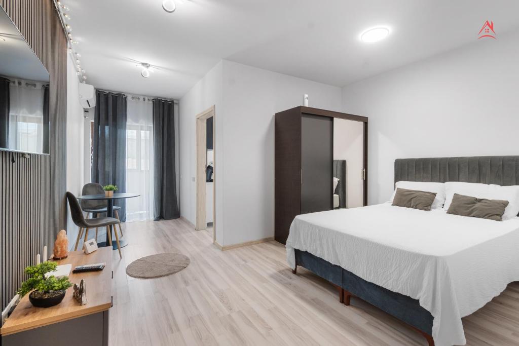 a bedroom with a large bed and a desk with a chair at Crina Studio in Bragadiru