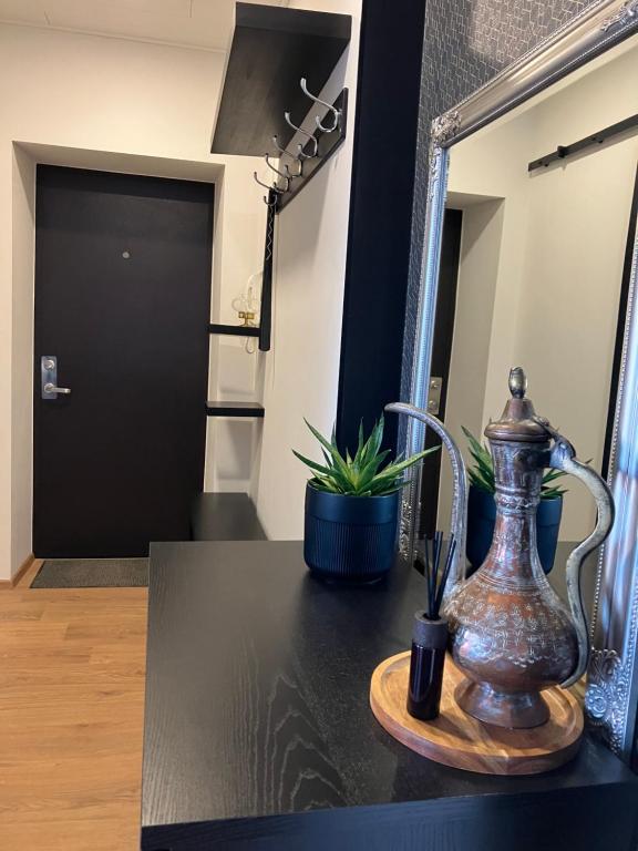 a table with a vase on a table with a mirror at Alvooria Living in Tapa