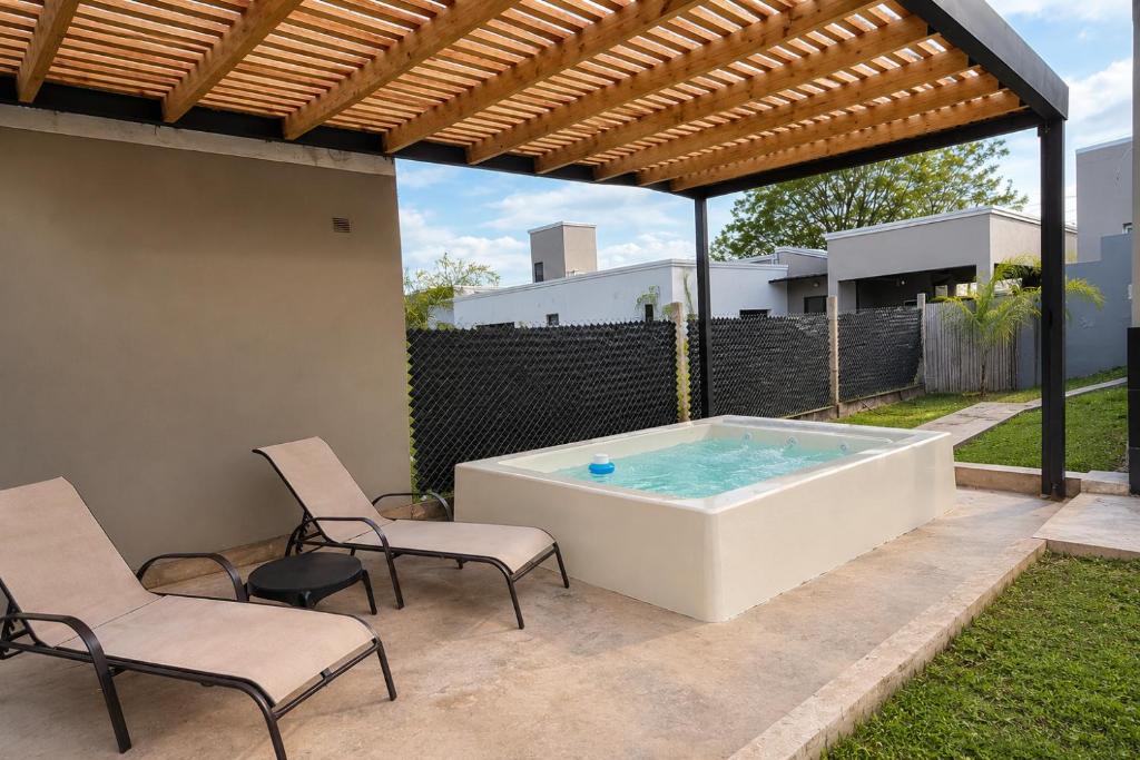 a hot tub on a patio with two chairs at Casa de los Cerros II in Vaqueros