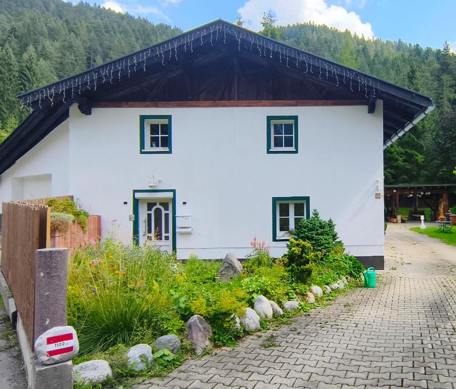 a white house with a black roof at Haus am Seebach Leutasch Weidach in Leutasch