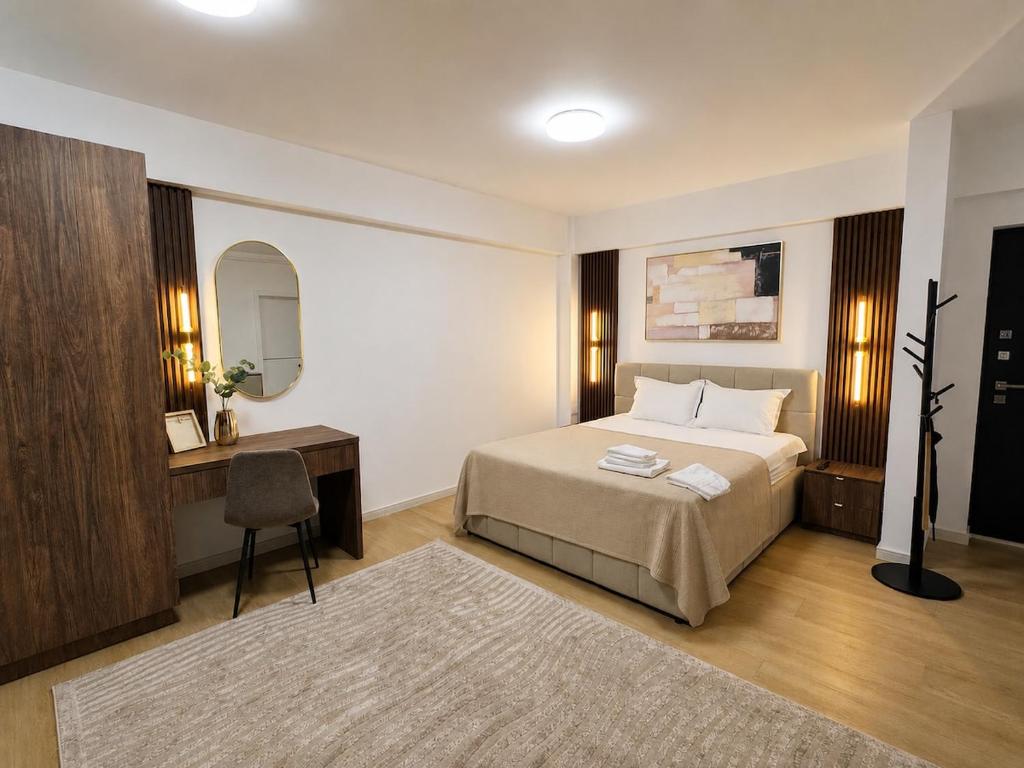 a bedroom with a bed and a desk and a chair at Piatra Studio Garden in Piatra Neamţ