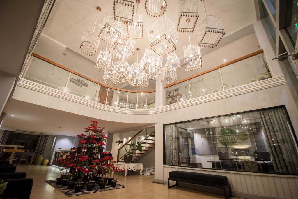 un vestíbulo con una lámpara de araña y un árbol de Navidad en Almont City Hotel, en Butuán
