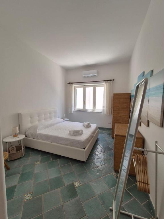 a white bedroom with a bed and a window at Casa Cachepot - Sweet Silvana in Ischia