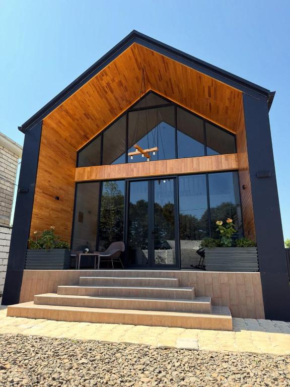 a large building with glass windows and stairs in front at Calm Barnhouse Lankaran in Lankaran