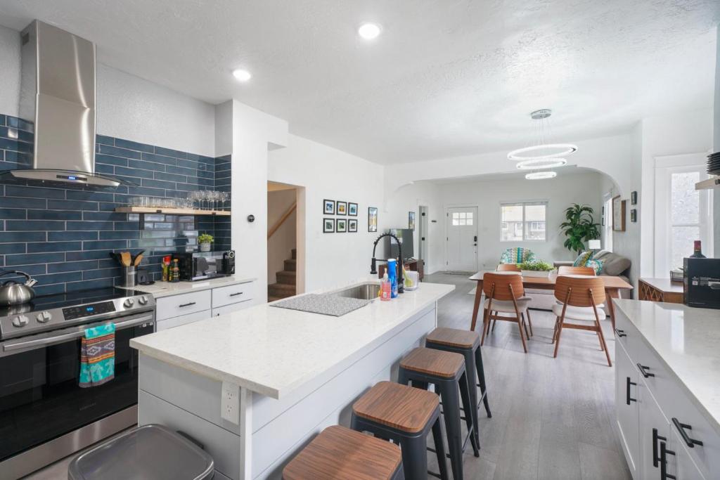 a kitchen with a white counter and stools in it at Ogden Base Camp in Ogden