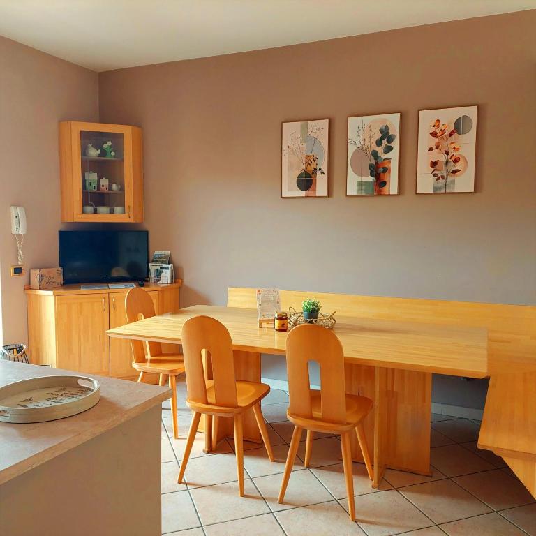 a dining room with a wooden table and chairs at Casa ai Tre Colli, Tres in Tres