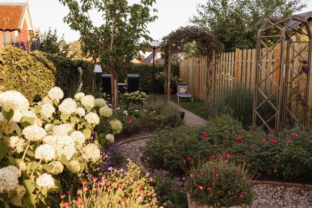 ein Garten mit weißen Blumen und einem Holzzaun in der Unterkunft Schöne Lage in Lage