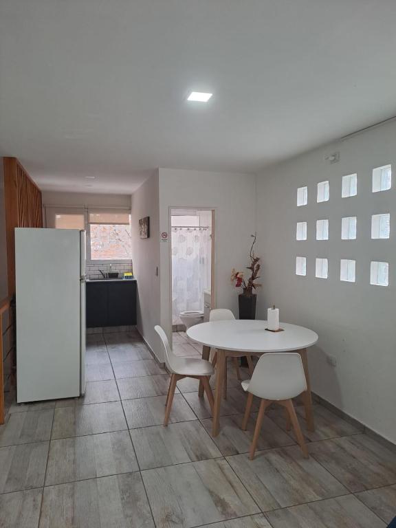 a dining room with a table and white chairs at Aires de la costa Renovado in Neuquén