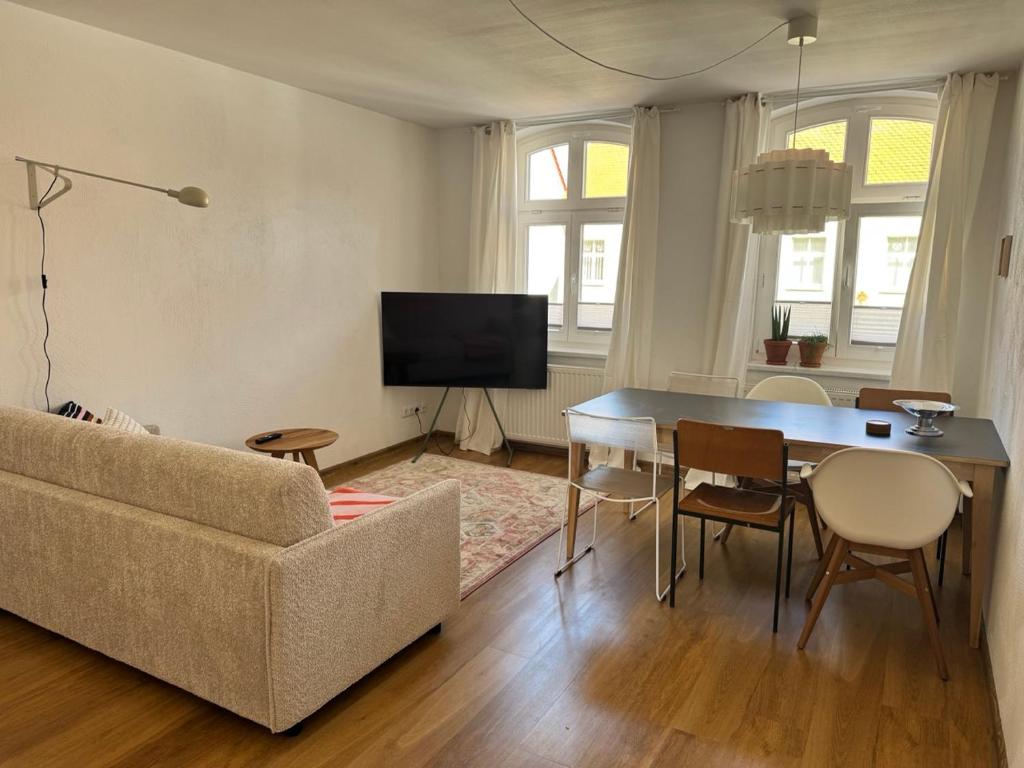 a living room with a couch and a table and chairs at Wohnen am Prenzlauer Tor in Pasewalk