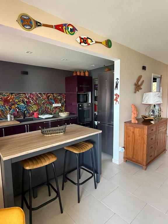 a kitchen with a large island with stools in it at Flamingo Bay in Les Trois-Îlets