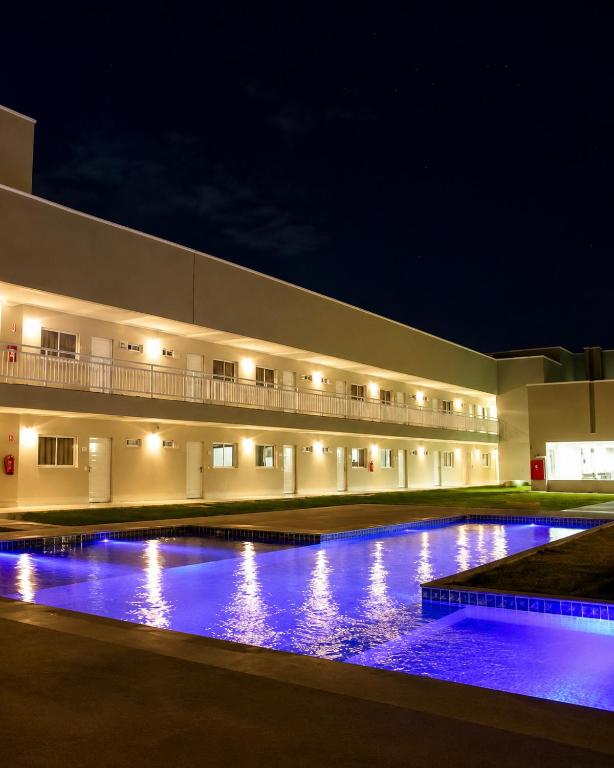 a building with a large swimming pool at night at Hotel Imperador in Gurupi