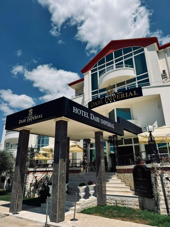 a hotel building with a sign in front of it at Hotel Dabi Imperial in Donji Štoj