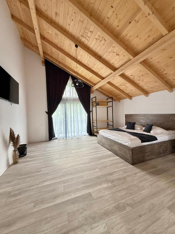 a large bedroom with two beds and a wooden ceiling at Austrian Villa's in Covasna