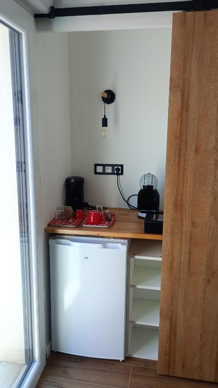 a kitchen with a counter and a white refrigerator at Chambre chez sylvie in Laruns