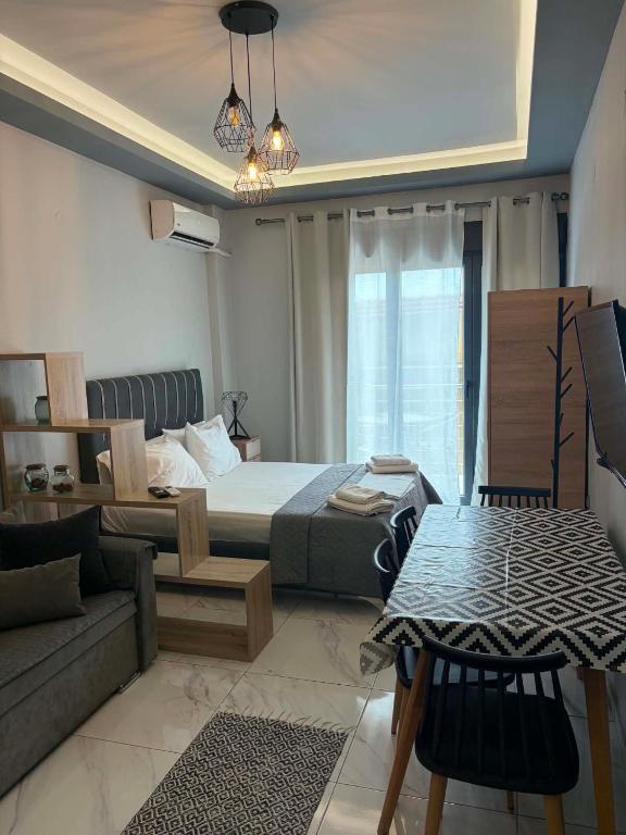 a bedroom with a bed and a couch and a table at Greysuites in Kavála