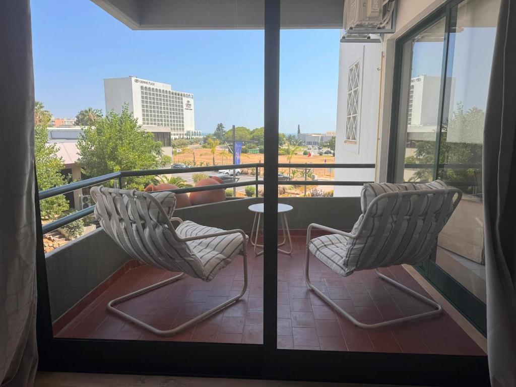 a balcony with two chairs and a table on a balcony at Vilamoura Marina Beach Apartament in Quarteira
