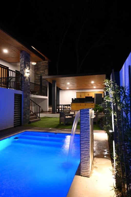 a swimming pool in front of a house at night at villa serenity in Jarabacoa