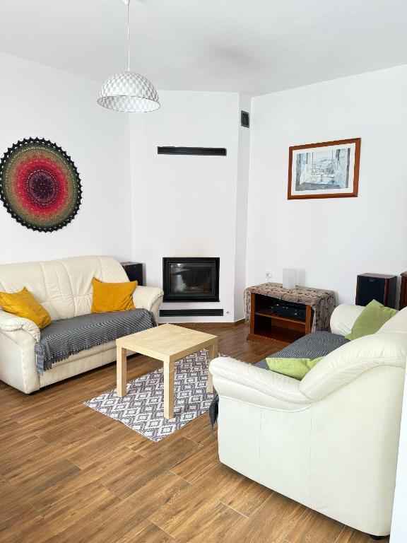 a living room with two white couches and a table at Chata Białobrzeg in Białobrzeg Dalszy