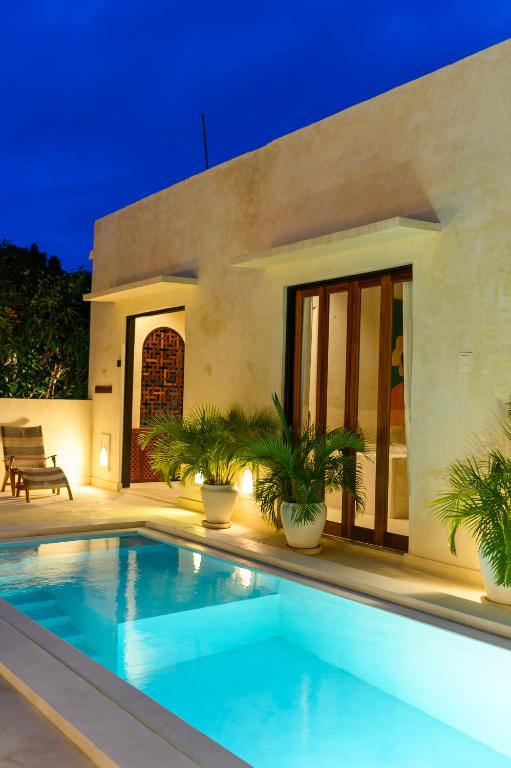 a villa with a swimming pool at night at Tulia House Lamu in Lamu