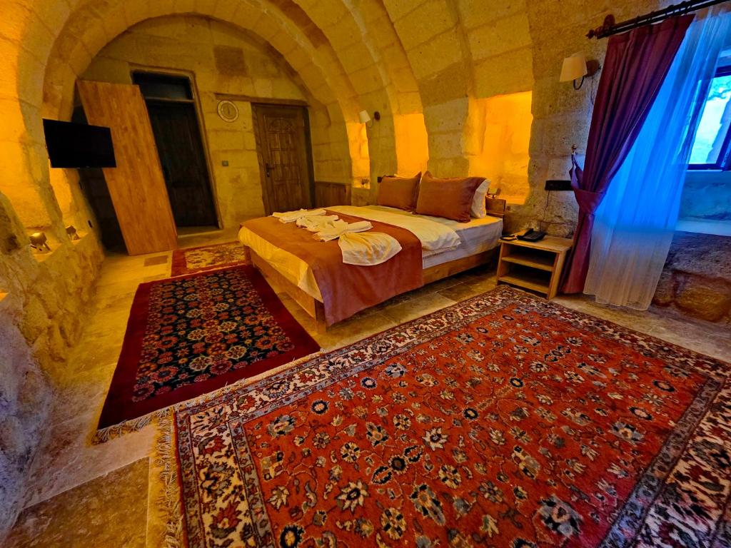 a bedroom with a bed and a red rug at Süleyman Cappadocia - Hot Air Balloon View in Göreme