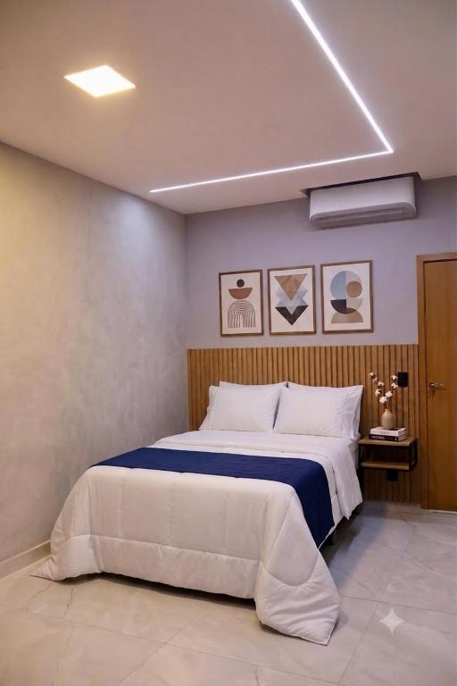 a bedroom with a large bed with a blue blanket at Espaço inteiro apartamento com escritório in Ananindeua