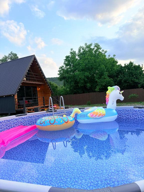 a swimming pool with two inflatables in the water at Cottage Orion in Sakramulo
