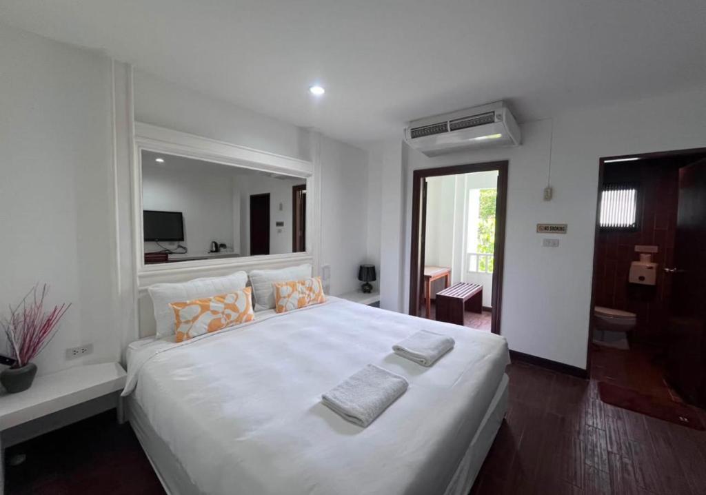 a bedroom with a large white bed with two towels on it at Hotel Park Star Premium Rooms in Tājganj