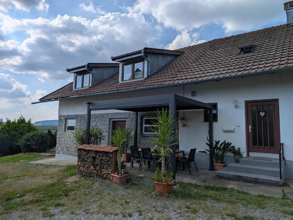 a house with a table and chairs in front of it at Ferienunterkunft Woidwärts in Schwarzach