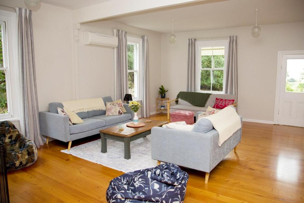 a living room with two couches and a table at Cath's cottage in Diamond Harbour
