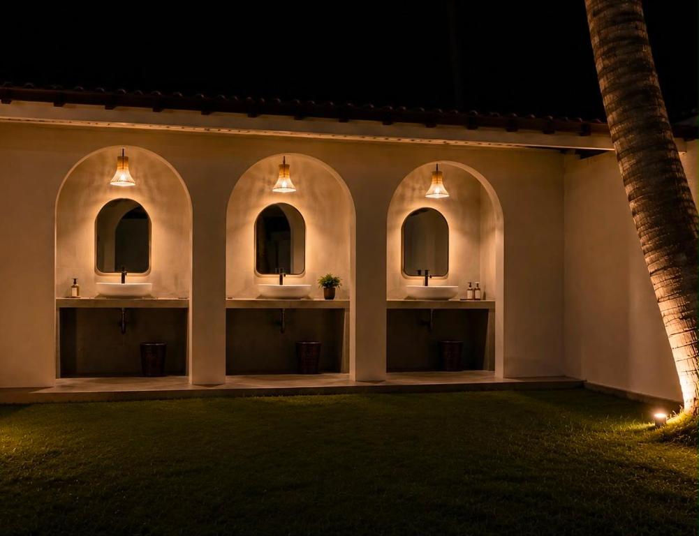 a group of three sinks in a building at night at Curve Ahangama in Ahangama