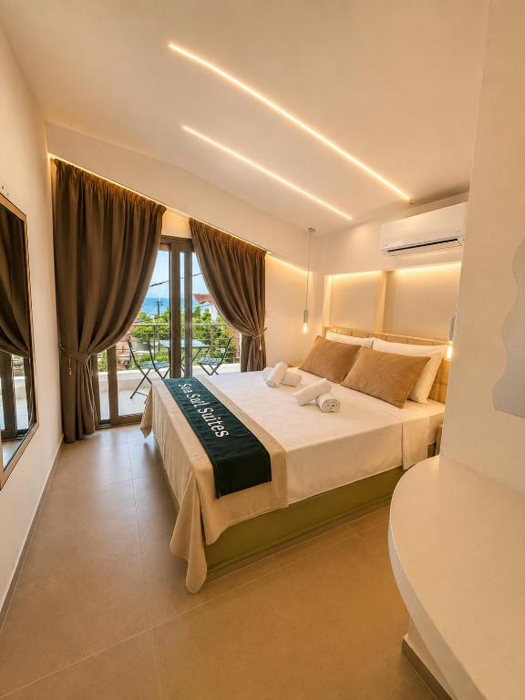 a bedroom with a large bed and a balcony at Sea Salt Maisonettes Samos in Ireon