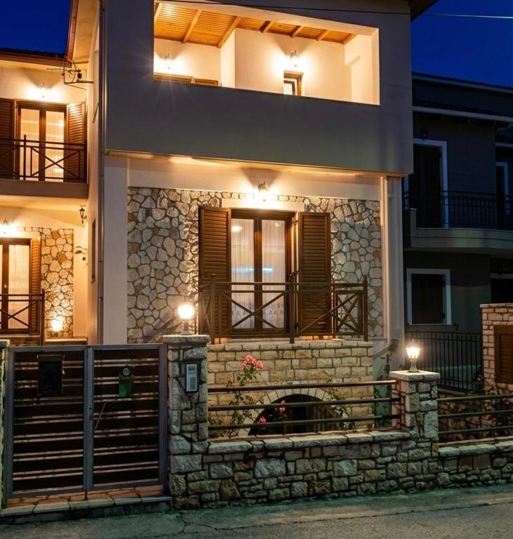 a house with a stone wall and a balcony at Dreamcatcher Maizonette No. 3 in Kalavrita