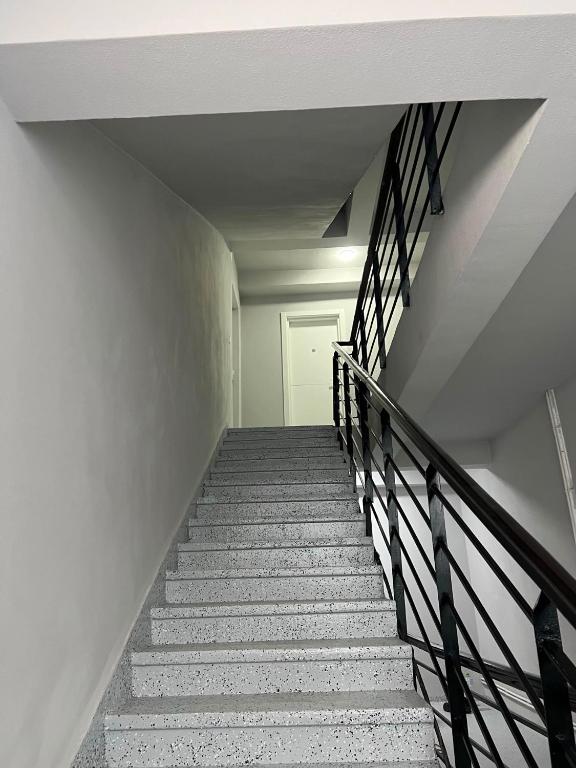 a stairway leading up to a white room at Achim-House in Beiuş